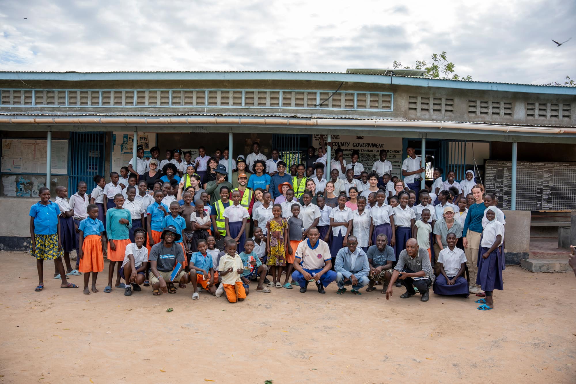 The whole school community gathered with the UT GivePower trek team outside their classrooms in Kenya