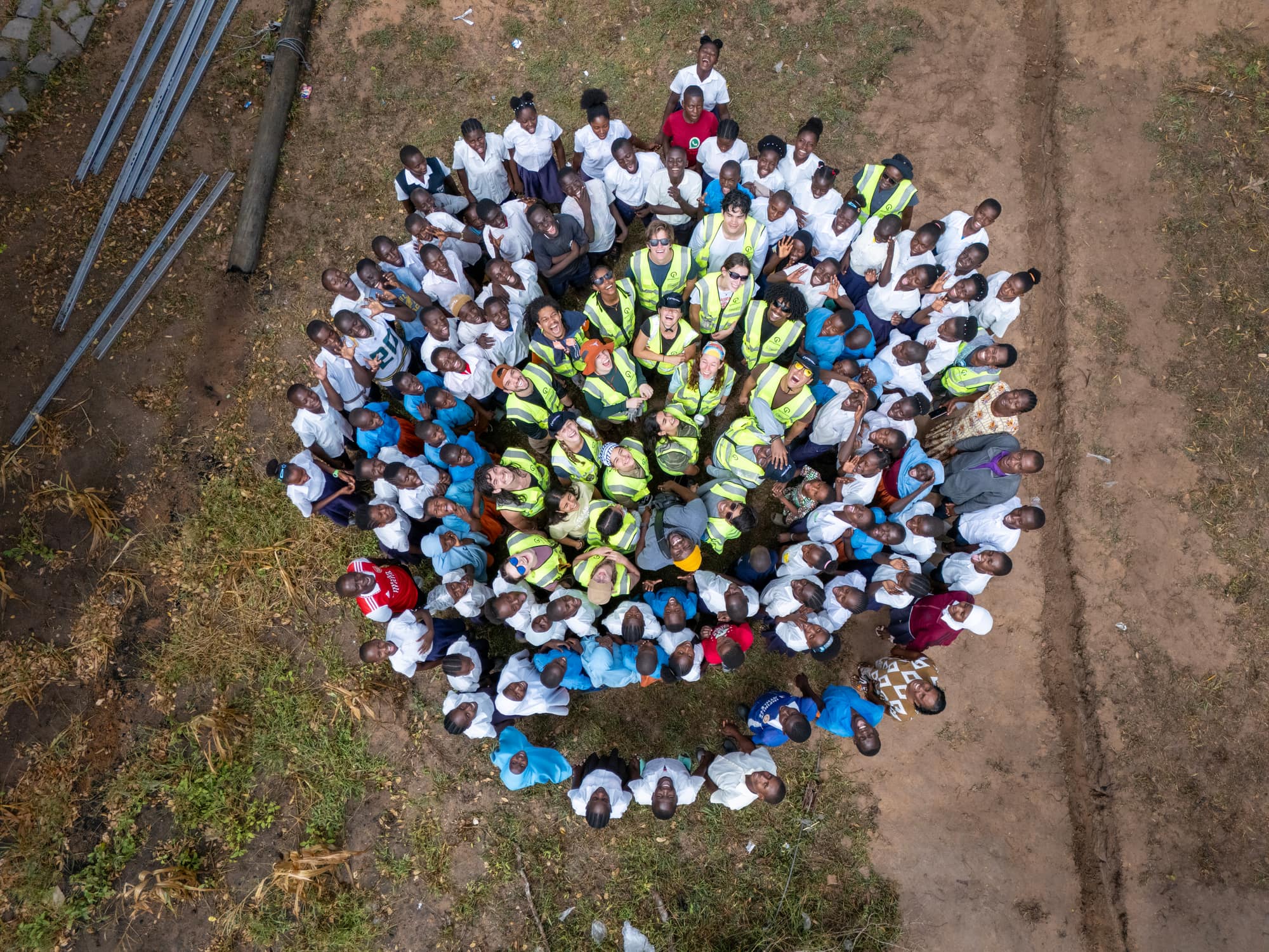 The UT GivePower trek team and Muryachakwe community members in front of a newly installed solar array in Kilifi County, Kenya